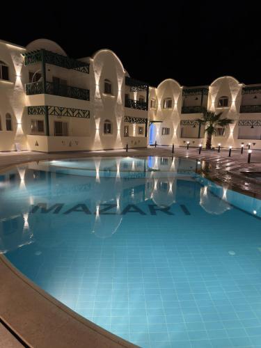 a large swimming pool at night at Sea-View 1BR Apartment Balcony Full Kitchen Resort in Marsa Alam City