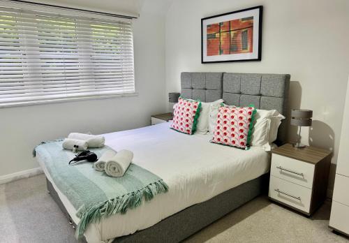 a bedroom with a bed with pillows and a window at Quiet 2 Bedroom Apartment in Headington, Close to Oxford Hospitals & Brookes University in Oxford