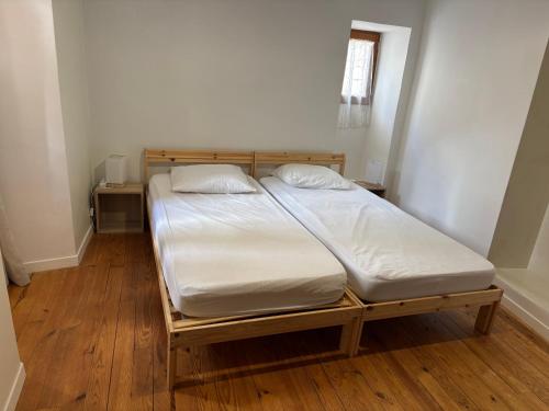 a bed with white sheets and pillows in a room at Logement Sainte-Énimie in Sainte-Énimie