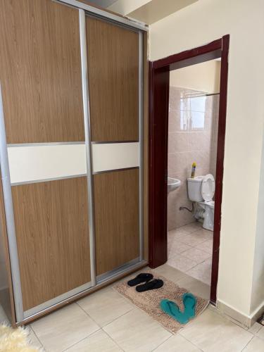 a bathroom with a sliding shower door with a pair of shoes at Alyahomes in Nairobi