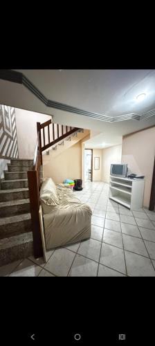 a bedroom with a staircase and a bed in a room at Casa Marron in Anchieta