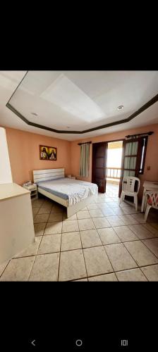 a bedroom with a bed and a tiled floor at Casa Marron in Anchieta
