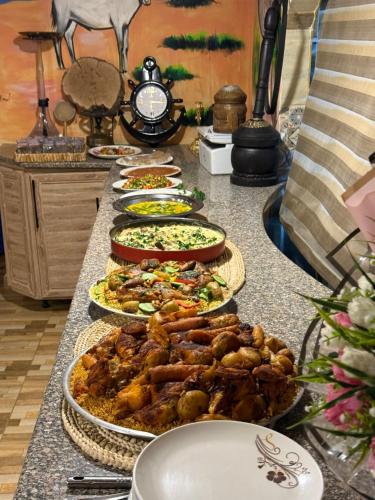 a buffet with many plates of food on a table at Dana in Tufailah