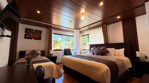 a bedroom with two beds and a table in it at Allincay Cusco Apart Hotel in Cusco