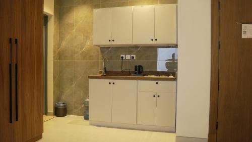a kitchen with white cabinets and a sink at فندق روزز إس in Riyadh