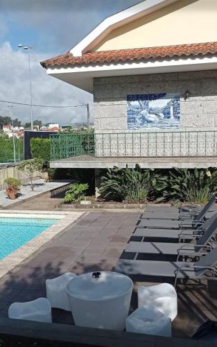 a pool with chairs and a bath tub next to a building at CASA CAMPO DA FEIRA in Felgueiras