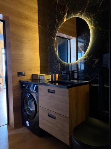 a bathroom with a washing machine and a mirror at Мої Гори in Pilipets