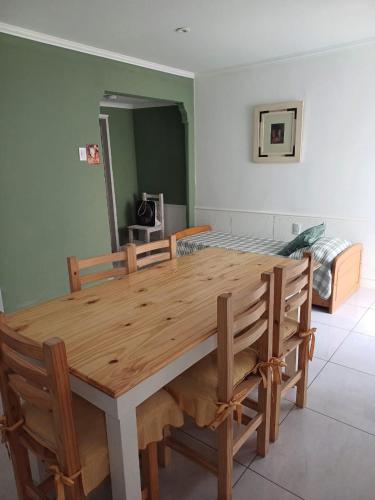 a wooden dining room table with two chairs and a bed at il Mandarino in Bahía Blanca