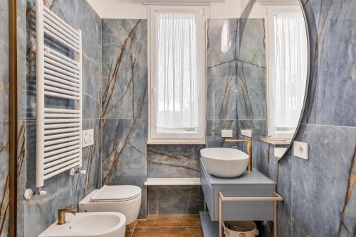 a bathroom with a sink and a toilet and a mirror at luxury apartament in Viareggio