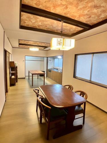 a dining room with a wooden table and chairs at イマヅのかくれ家 in Fukuoka