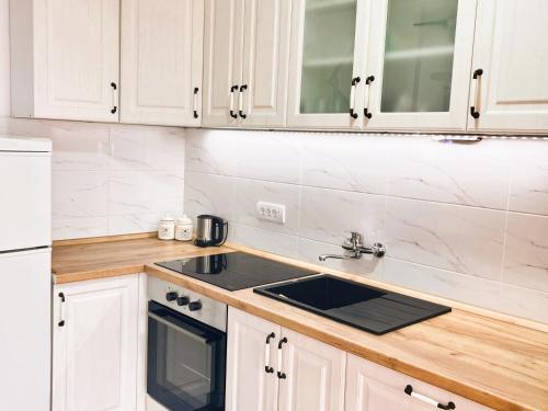 a kitchen with white cabinets and a sink at Vikend kuca pod lipom in Rudnik