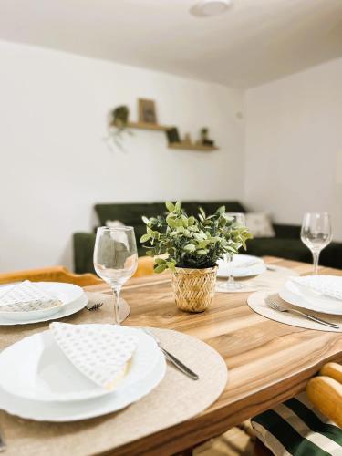 a wooden table with white plates and wine glasses at Vikend kuca pod lipom in Rudnik