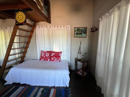 a bedroom with a bed with a red pillow at Isla Casinha Delta Tigre in Tigre