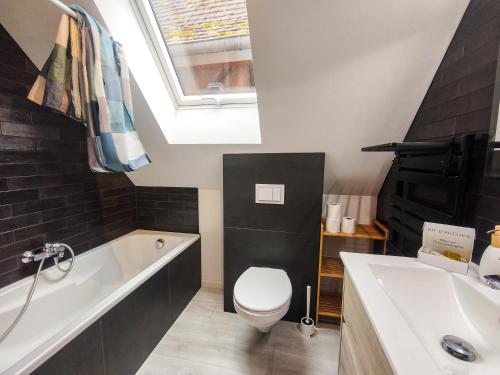 a bathroom with a toilet and a tub and a sink at Mackenheim - Parenthèse détente en Alsace - Terrasse & Parking in Mackenheim