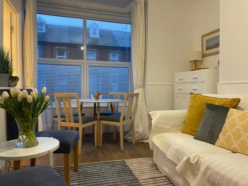 a living room with a couch and a table at Harbour House Holiday Apartments in Bridlington