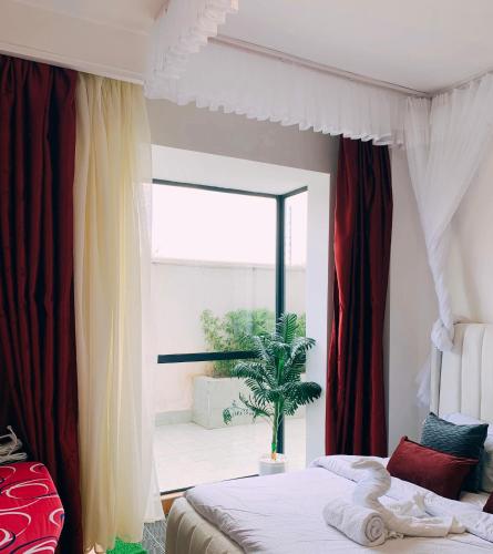 a bedroom with a bed and a large window at Carl's Peace Haven in Gachie