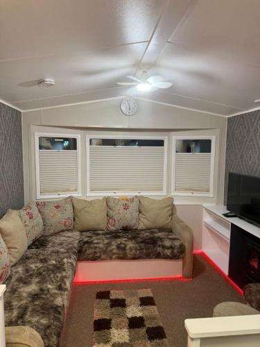 a living room with a couch and a clock on the ceiling at Oakley Newquay Bay Resorts in Newquay Bay Resort