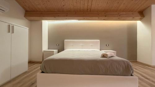 a bedroom with a white bed with a wooden ceiling at Forlì City Residence in Forlì