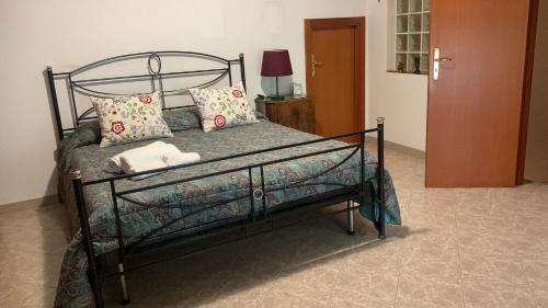 a bed with a metal frame and pillows on it at La Panchina sul Corso in Grassano