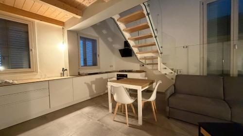 a small kitchen with a table and a spiral staircase at Forlì City Residence in Forlì