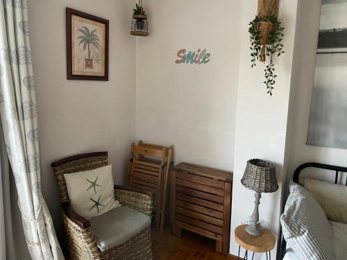a corner of a bedroom with a chair and a table at Apartamento con vistas espectaculares al rio Sella in Ribadesella