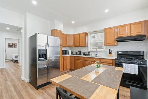 a kitchen with a table and a stainless steel refrigerator at Cozy Retreat 15Min to NYC, FIFA, Mall,FREE Parking - Apartment in North Bergen