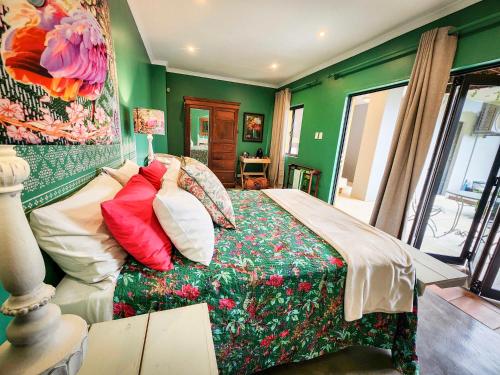 a bedroom with green walls and a bed with pillows at Le Chemin Guesthouse - 6 sleeper in Kloof