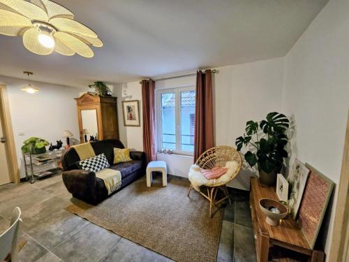 a living room with a couch and a chair at Appartement Le petit Bretzel in Neuwiller-lès-Saverne