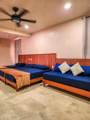 a bedroom with two beds and a ceiling fan at Family Studio Suite with Kitchenette & Terrace - Santuario Hotel Boutique in Chemuyil