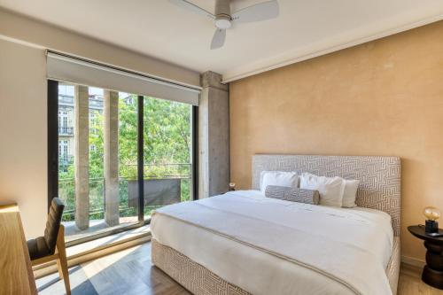 a bedroom with a large bed and a large window at OWA Wellness Center in Mexico City