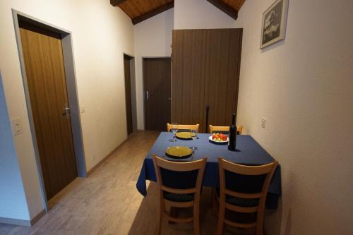 a dining room with a blue table and chairs at Haus Amor in Saas-Fee
