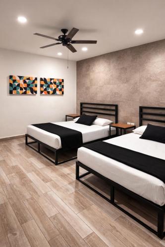 a bedroom with two beds and a ceiling fan at Capital Hotel Saltillo in Saltillo
