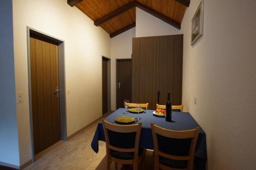 a dining room with a blue table and chairs at Haus Amor in Saas-Fee