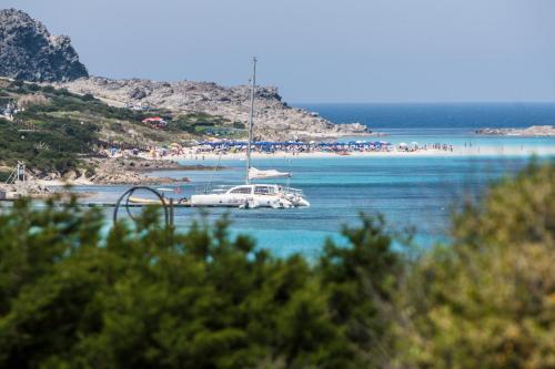 a boat in the water with a beach in the background at Villa Gino in Stintino