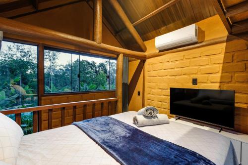 a bedroom with a bed and a large window at Chalé com hidro em meio a natureza in Brasília