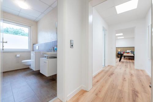 a white bathroom with a sink and a toilet at Orange Suite Schliengen 2 in Schliengen