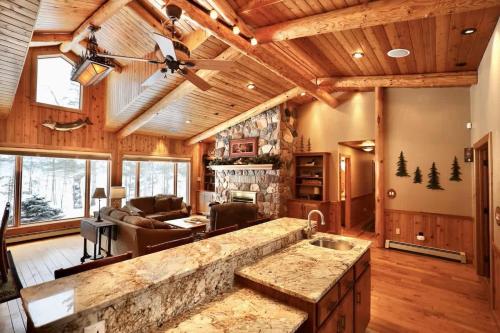 a kitchen and living room in a log cabin at Big Arbor Pines Family friendly in Woodruff