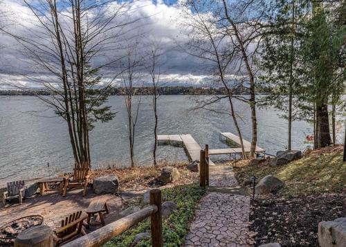 a group of benches sitting next to a body of water at Big Arbor Pines Family friendly in Woodruff
