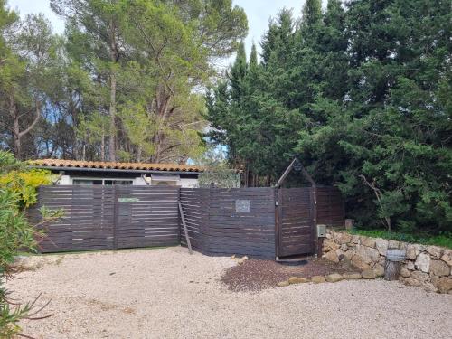 a wooden fence in front of a house at A l'Orée des pins - Gite et spa de 30 m2- Options Home Cinéma, Romantique in Cuges-les-Pins