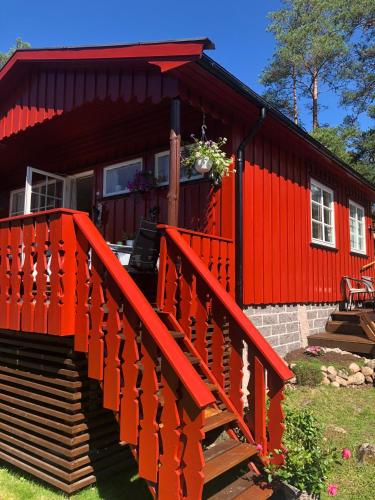 a red house with a staircase in front of it at Flott hytte - Enhus, Kråkerøy in Fredrikstad