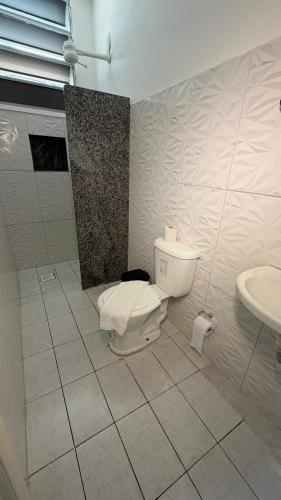 a bathroom with a toilet and a sink at Hotel Brasilia in Aracaju