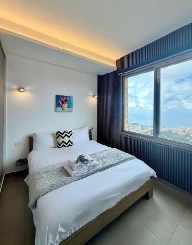 a bedroom with a large bed with a large window at Mini 1BR Studio Central Broumana with Sea View in Broummana