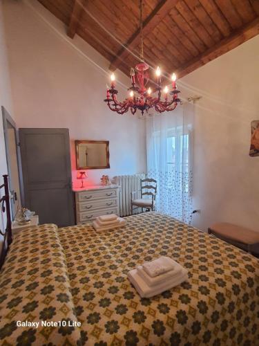 a bedroom with a bed and a chandelier at Le dimore del Mercante in Luco neʼ Marsi