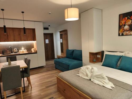 a bedroom with a bed and a table and a couch at SKYLINE apartments Kopaonik in Kopaonik