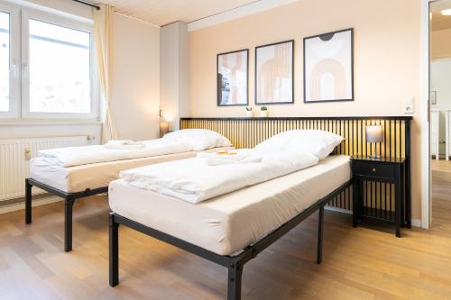two beds in a room with two windows at Orange Suite Schliengen 1 in Schliengen