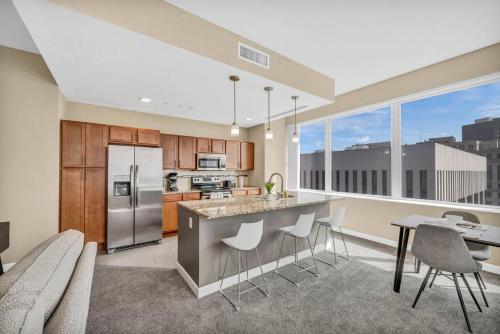 an open kitchen with a counter and chairs and a large window at 21st Floor Penthouse | Amazing Views of Downtown! in Cleveland