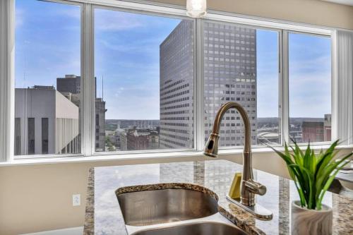 a kitchen with a sink and a large window at 21st Floor Penthouse | Amazing Views of Downtown! in Cleveland