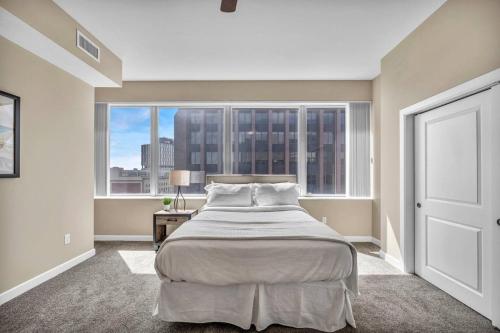 a bedroom with a bed and a large window at 21st Floor Penthouse | Amazing Views of Downtown! in Cleveland