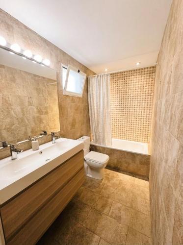 a bathroom with a sink and a toilet and a tub at Sevilla Family House - La casa de Marta in Montequinto