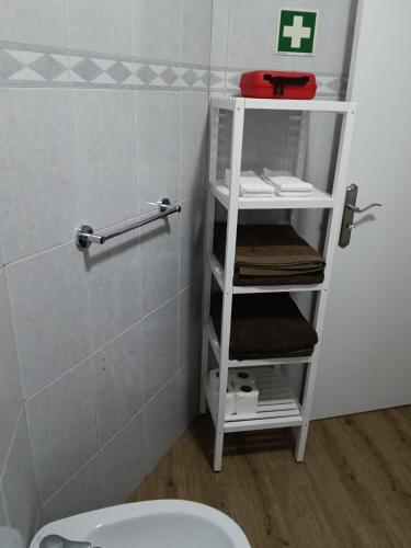 a bathroom with a white toilet in a room at Casa do Negrão in Ponta Delgada